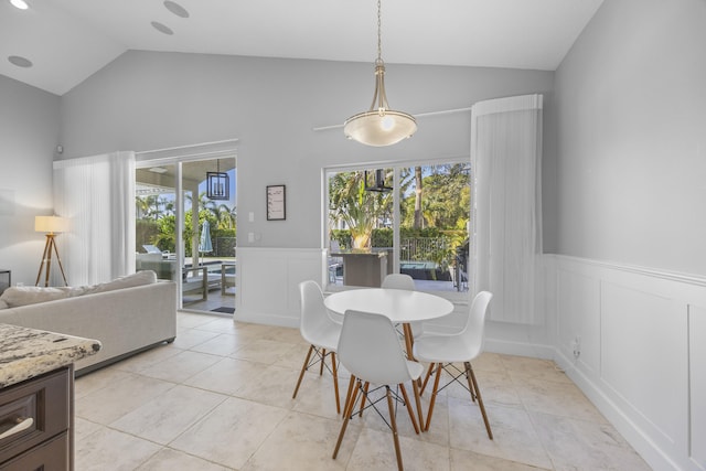 dining space featuring light tile patterned floors and vaulted ceiling