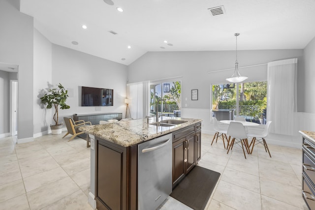 kitchen featuring a kitchen island with sink, dishwasher, hanging light fixtures, dark brown cabinetry, and sink