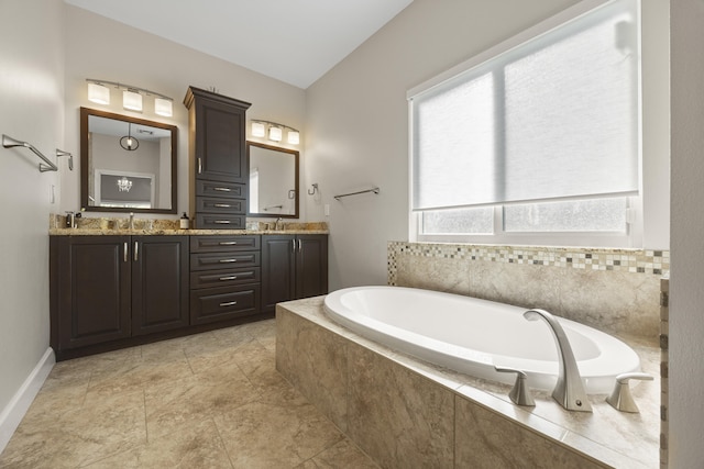 bathroom featuring tiled bath and vanity