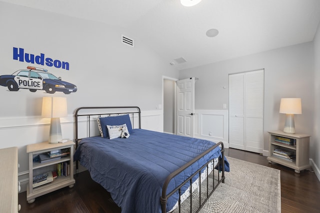 bedroom with dark wood-type flooring, a closet, and vaulted ceiling