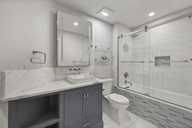 full bathroom featuring combined bath / shower with glass door, vanity, and toilet