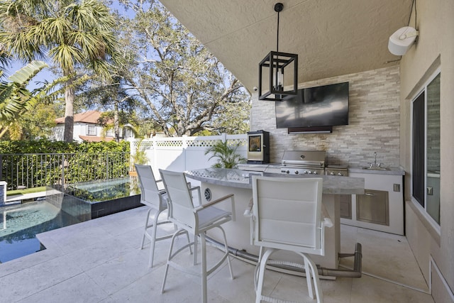 view of patio with a wet bar, a fenced in pool, and area for grilling