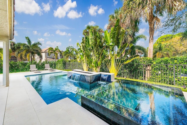 view of swimming pool featuring pool water feature, an in ground hot tub, and a patio