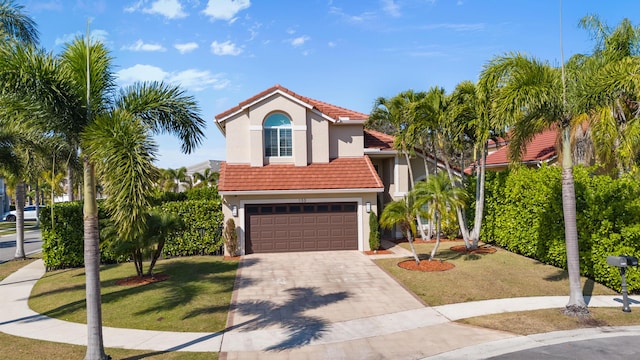 mediterranean / spanish-style house featuring a garage and a front lawn