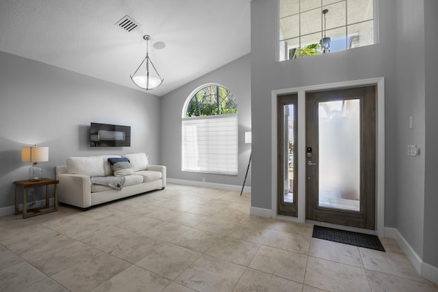 tiled entryway featuring high vaulted ceiling