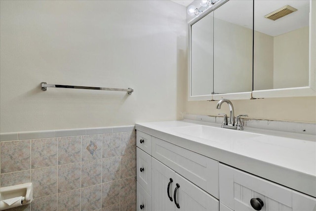 bathroom featuring vanity and tile walls