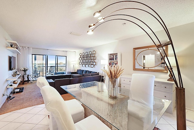 dining area with a textured ceiling and light carpet