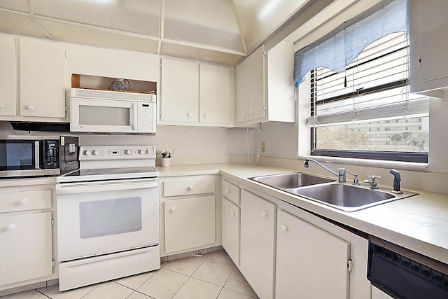 kitchen featuring light tile patterned flooring, white appliances, white cabinetry, and sink