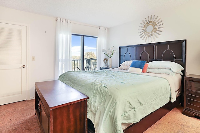 bedroom featuring access to exterior, carpet floors, and a textured ceiling