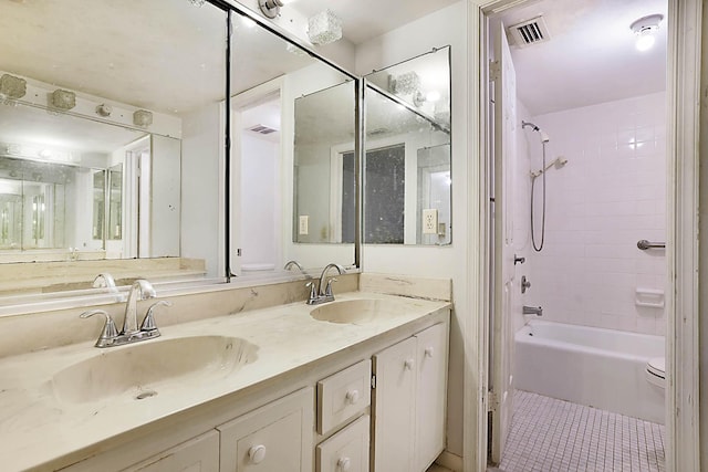 bathroom featuring tile patterned floors, tiled shower / bath combo, and vanity