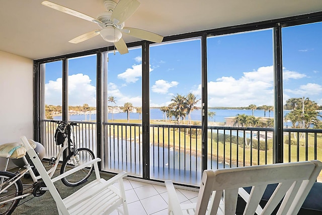 sunroom / solarium with a water view and ceiling fan