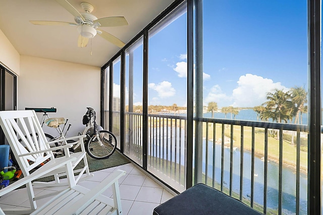 unfurnished sunroom featuring a water view and ceiling fan