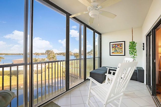 sunroom / solarium featuring ceiling fan and a water view