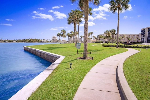 view of property's community featuring a lawn and a water view