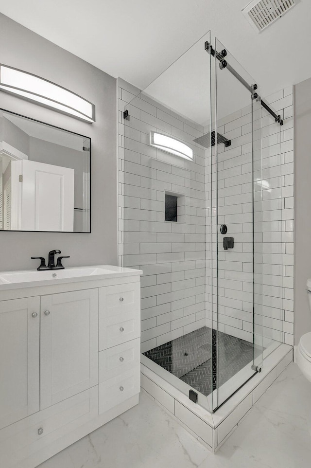 bathroom with toilet, an enclosed shower, and vanity