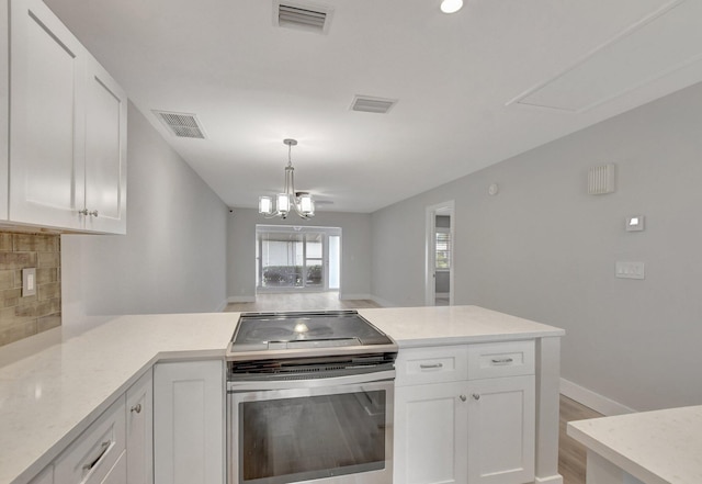 kitchen featuring white cabinets, a chandelier, backsplash, and stainless steel range with electric stovetop