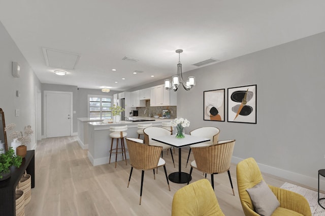 dining space featuring an inviting chandelier and light hardwood / wood-style flooring