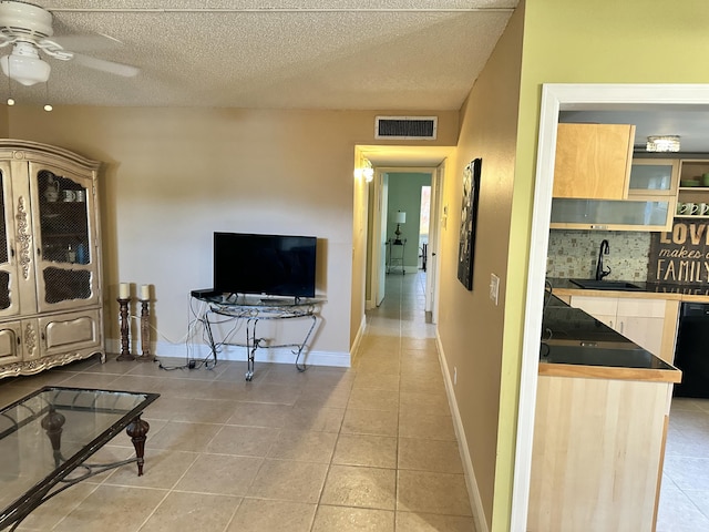 interior space featuring light tile patterned floors, a textured ceiling, and sink