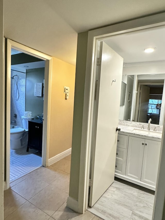 bathroom featuring tile patterned flooring, vanity, and  shower combination