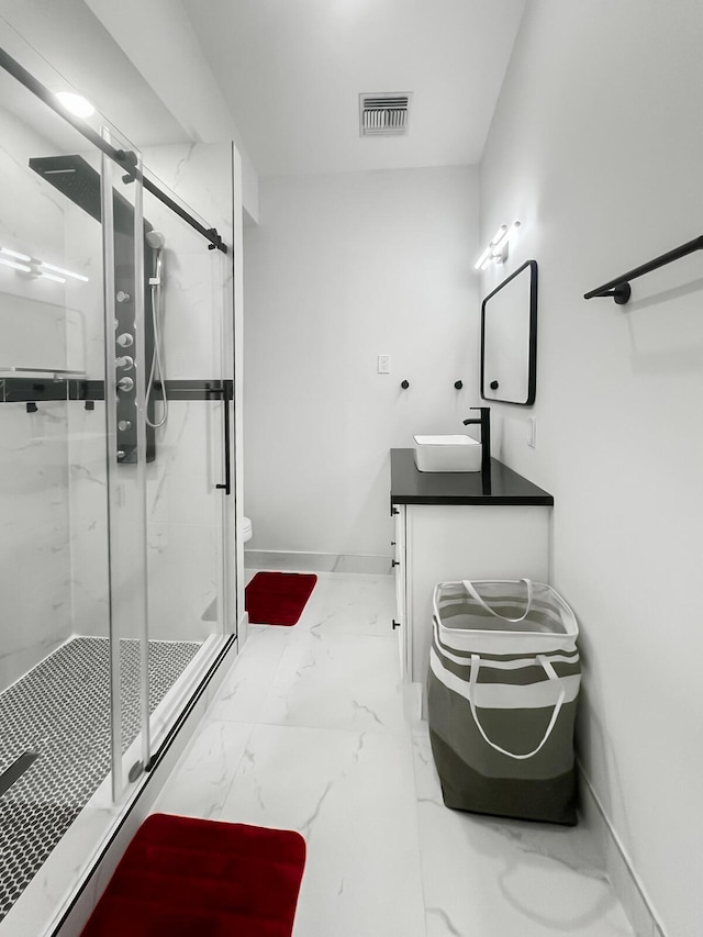 bathroom with vanity, toilet, and a shower with shower door