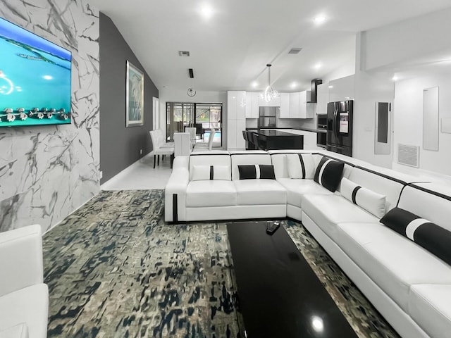 living room featuring lofted ceiling and an inviting chandelier