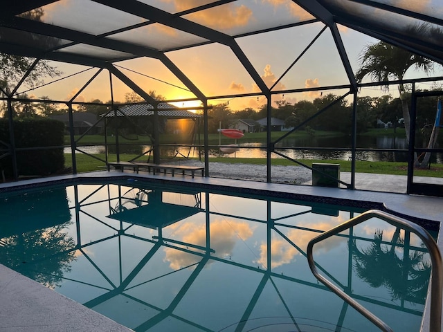 pool at dusk featuring a lanai, a water view, and a patio