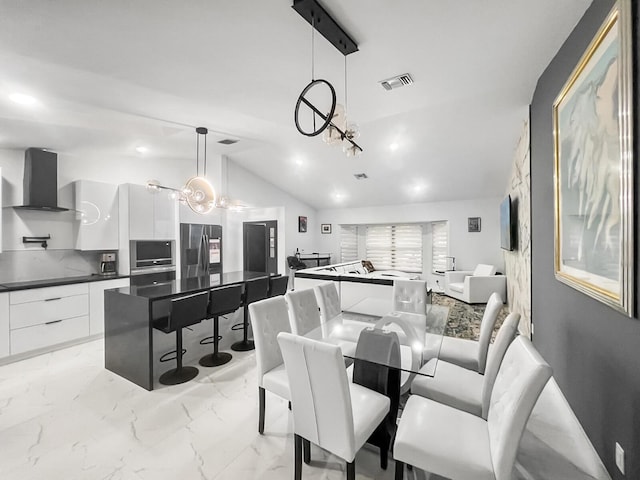 dining area with vaulted ceiling and an inviting chandelier