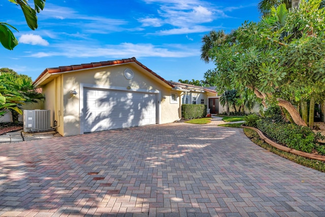 view of front of property featuring a garage and central AC