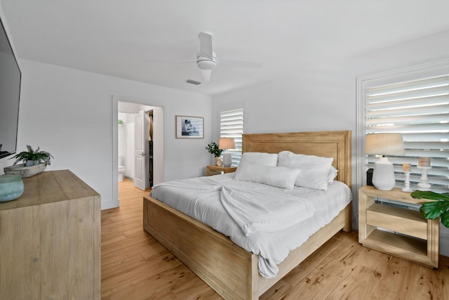 bedroom with ceiling fan, light hardwood / wood-style flooring, and ensuite bath