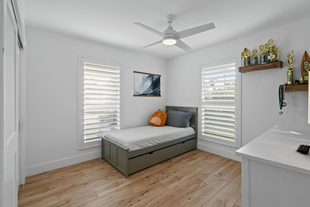 bedroom with ceiling fan, light wood-type flooring, and multiple windows