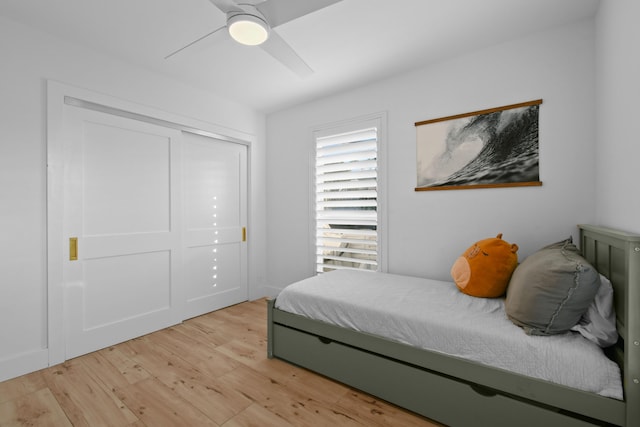 bedroom with ceiling fan, light hardwood / wood-style floors, and a closet