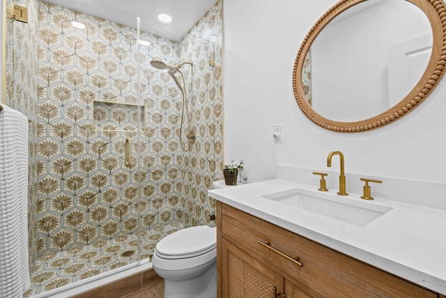 bathroom with walk in shower, vanity, and toilet