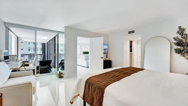 bedroom featuring light tile patterned floors and a wall of windows