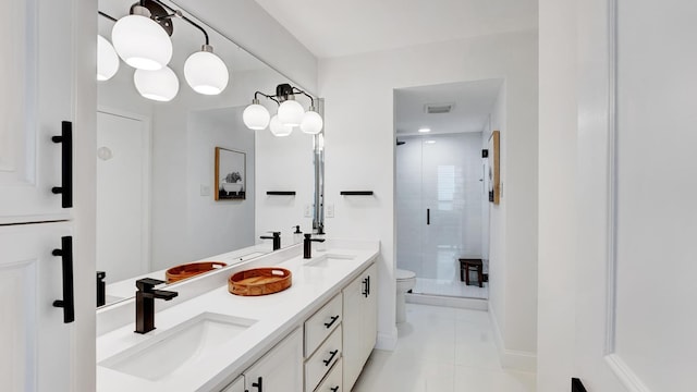 bathroom featuring tile patterned flooring, vanity, toilet, and a shower with shower door