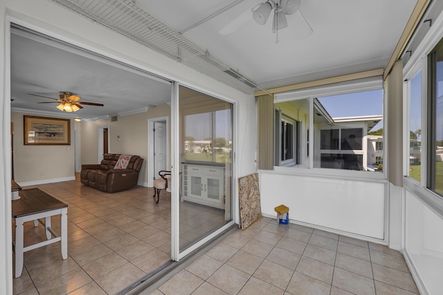 unfurnished sunroom with ceiling fan and a healthy amount of sunlight