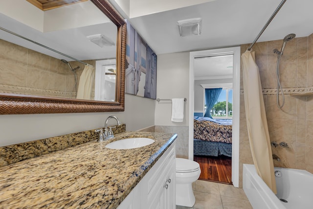 full bathroom featuring shower / bath combo, tile patterned floors, toilet, vanity, and tile walls