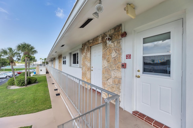 view of exterior entry featuring a lawn