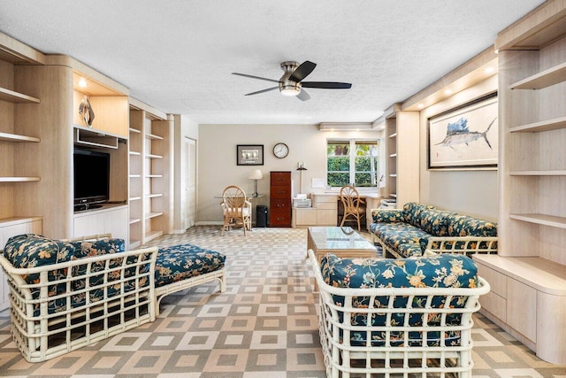 living room featuring a textured ceiling and ceiling fan