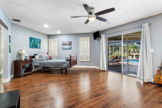 bedroom featuring visible vents, hardwood / wood-style flooring, a textured ceiling, baseboards, and access to exterior