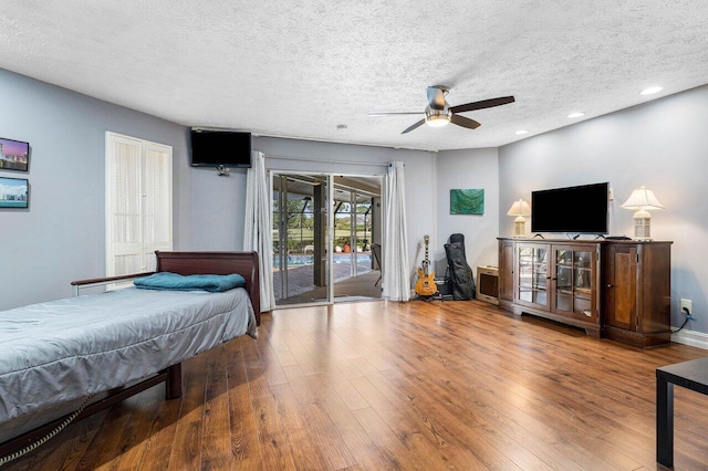 bedroom with ceiling fan, recessed lighting, wood finished floors, a textured ceiling, and access to outside