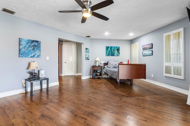 bedroom with visible vents, a textured ceiling, wood finished floors, recessed lighting, and baseboards