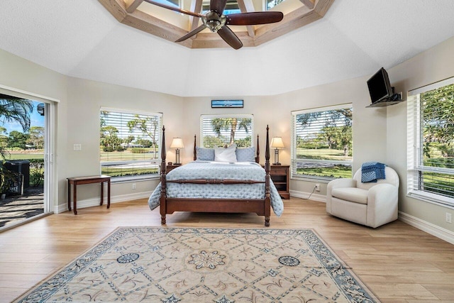 bedroom featuring access to exterior, a textured ceiling, light wood-style floors, ceiling fan, and vaulted ceiling