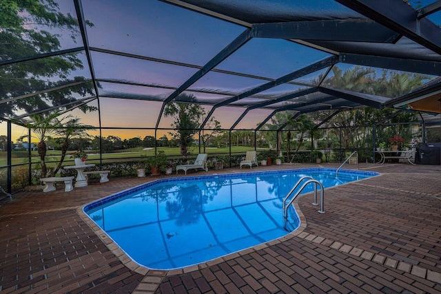 outdoor pool featuring glass enclosure and a patio area