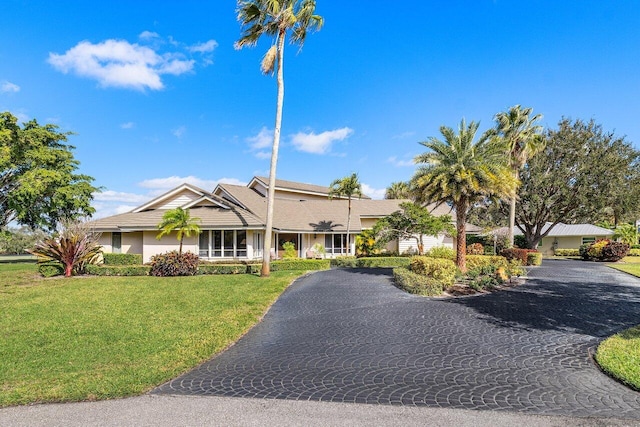 ranch-style house with aphalt driveway and a front lawn