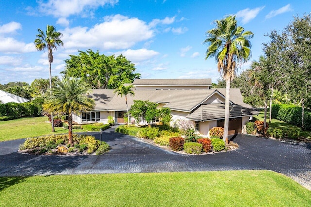 view of front of house featuring a garage, a front yard, and driveway