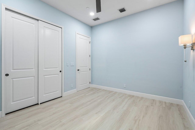 unfurnished bedroom with ceiling fan, a closet, and light wood-type flooring