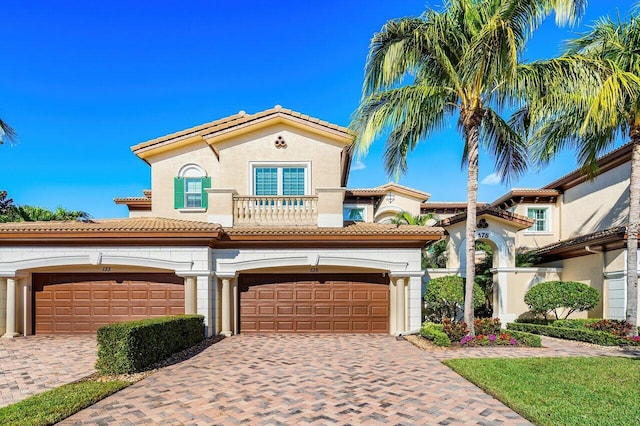 mediterranean / spanish-style house featuring a garage and a balcony