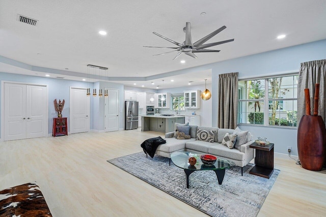 living room with ceiling fan and light hardwood / wood-style floors