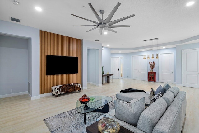 living room with light hardwood / wood-style flooring and ceiling fan