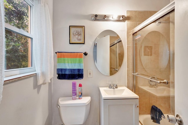 bathroom with vanity, toilet, and a shower with door